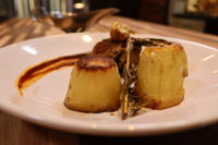 Filet Mignon with Demi-Glace Sauce Plated Filet Mignon with Demi-Glace Sauce: seared meat, two fondant potatoes, rosemary, and sauce swirl.