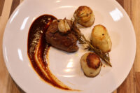 Filet Mignon with Demi-Glace Sauce Seared Filet Mignon with Demi-Glace Sauce, fondant potato halves, and rosemary sprig on a white plate
