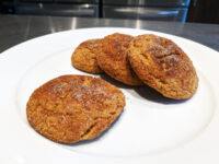 Gingersnap Cookies Four Gingersnap Cookies with cracked, sugar-crusted tops on a white plate.