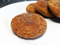 Gingersnap Cookies Close-up of sugar-coated Gingersnap Cookies with cracked tops, piled on a white plate.