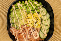 Poke Bowl with Salmon Poke Bowl with Salmon topped with avocado, edamame, mango, cucumber, sesame seeds and spicy mayo drizzle