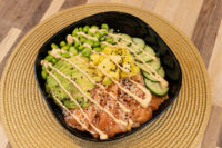 Poke Bowl with Salmon Poke Bowl with Salmon topped with avocado, edamame, mango, cucumber, sesame seeds, and spicy mayo drizzle