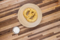 Garlic Dipping Sauce for Pretzels A small glass bowl of Garlic Dipping Sauce for Pretzels next to a mustard-seed pretzel on a wooden table.