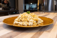 Halušky with Sauerkraut Mounded Halušky with Sauerkraut on a gold plate, topped with a fresh herb sprig, on a wooden countertop