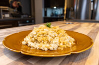 Halušky with Sauerkraut Mound of Halušky with Sauerkraut on a gold plate, topped with a sprig of parsley.