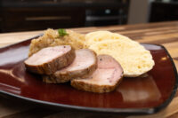 Sliced pork, sauerkraut, and dumpling slices plated for Pork-Sauerkraut-Dumpling (Vepřo-knedlo-zelo)