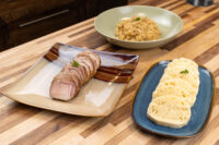 Sliced pork, rounds of Czech dumpling, and a bowl of sauerkraut for Pork-Sauerkraut-Dumpling (Vepřo-knedlo-zelo).