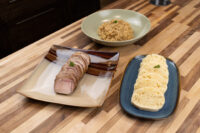 Sliced pork, stewed sauerkraut, and sliced dumplings plated for Pork-Sauerkraut-Dumpling (Vepřo-knedlo-zelo).