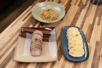 Sliced pork, a bowl of sauerkraut, and dumpling rounds plated for Pork-Sauerkraut-Dumpling (Vepřo-knedlo-zelo).