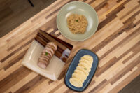 Pork, Sauerkraut, and Dumplings Sliced pork, a bowl of sauerkraut, and dumpling rounds for Pork-Sauerkraut-Dumpling (Vepřo-knedlo-zelo) on a wood table