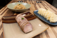 Sliced pork loin with a bowl of sauerkraut and sliced dumplings, plated for Pork-Sauerkraut-Dumpling (Vepřo-knedlo-zelo).
