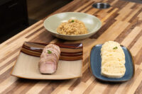 Sliced pork, a bowl of stewed sauerkraut, and sliced dumplings for Pork-Sauerkraut-Dumpling (Vepřo-knedlo-zelo)