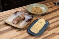Sliced roast pork, a bowl of stewed sauerkraut, and sliced dumpling rounds for Pork-Sauerkraut-Dumpling (Vepřo-knedlo-zelo)