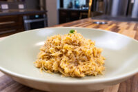 Sauerkraut (Kysane Zelí) A pale green bowl holds golden, shredded Sauerkraut (Kysane Zelí) topped with chopped herb.