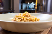Sauerkraut (Kysane Zelí) White bowl of shredded Sauerkraut (Kysane Zelí) topped with a light garnish and herb sprig on a wooden table.