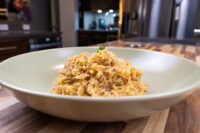 Sauerkraut (Kysane Zelí) Shredded Sauerkraut (Kysane Zelí) with red spice flecks and herb garnish in a pale bowl on wood.