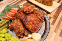 Czech BBQ – Honey Pork Ribs Czech BBQ – Honey Pork Ribs glazed pieces on a platter with tomato, kale, pickles, and pepperoncini