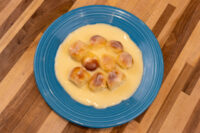Little Buns with Vanilla Pudding (Buchticky s Krémem): golden buns in custard on a blue plate.