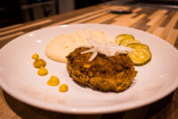 Karbenátky (Czech Burger) Fried Karbenátky (Czech Burger) patty topped with onion, served with mashed potato, mustard, and pickles.