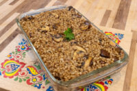 Baked Mushroom Kuba (Houbovy Kuba) with barley and mushrooms in a glass dish, topped with parsley.