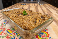 Baked Mushroom Kuba (Houbovy Kuba) in a glass dish, showing barley and mushroom pieces with a parsley garnish.
