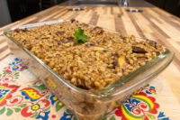 Baked Mushroom Kuba (Houbovy Kuba) with barley and mushrooms in a glass dish, garnished with parsley.