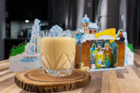 Czech Egg Liqueur – Czech Eggnog Glass of Czech Egg Liqueur – Czech Eggnog on a wooden slice, with a nativity decoration behind