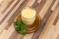 Czech Egg Liqueur – Czech Eggnog Glass of Czech Egg Liqueur – Czech Eggnog on a wooden slice, garnished with fresh mint leaves.