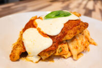 Chicken Parmesan Breaded Chicken Parmesan topped with marinara, melted mozzarella, and basil, plated over pasta