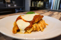 Chicken Parmesan Breaded Chicken Parmesan topped with melted mozzarella and marinara, served over tube pasta.