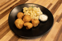 Plate of Fried Cauliflower Smažený Květák with diced potatoes and a bowl of creamy dip