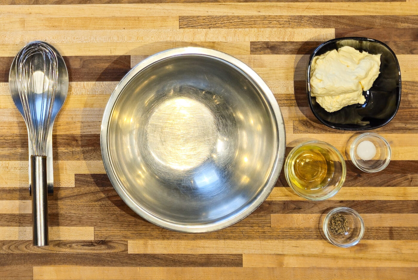 Mixing bowl, whisk, mayonnaise, pickle juice, salt, and pepper laid out for Czech Tartar Sauce Tatarka.