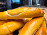Czech Rolls Rohliky Recipe Close-up of golden, glossy Czech Rolls Rohliky piled together, showing their shiny baked crust.