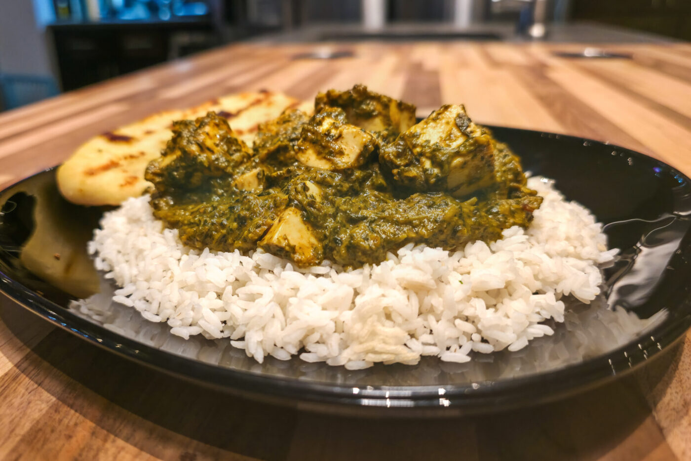 Spinach Palak Paneer Spinach Palak Paneer with diced paneer cubes in green curry, served over rice with grilled flatbread.