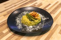 Asparagus Risotto with Shrimp Plated Asparagus Risotto with Shrimp topped with grilled shrimp and asparagus on a black dish.