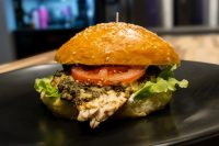 Pesto Chicken Sandwich with Parmesan Pesto Chicken Sandwich with Parmesan on a sesame bun with tomato and lettuce, skewer on top