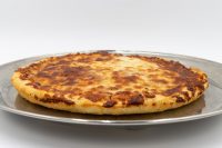 60 min. Pan Pizza Round 60 min. Pan Pizza with a thick golden crust and browned cheese top on a metal plate.
