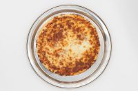 60 min. Pan Pizza Overhead shot of 60 min. Pan Pizza with browned melted cheese on a round metal pan