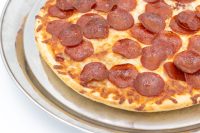 60 min. Pan Pizza Baked 60 min. Pan Pizza with pepperoni and melted cheese on a round metal tray.