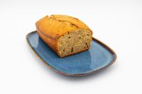 Sliced Banana Bread loaf with golden crust and moist crumb on a blue ceramic plate.