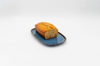 Sliced Banana Bread loaf with golden crust on a blue rectangular plate.