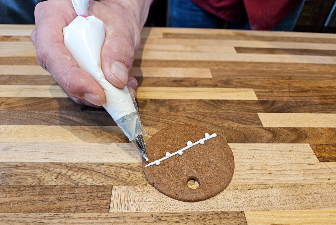 Demonstration of how to decorate gingerbread cookies as round ornaments.