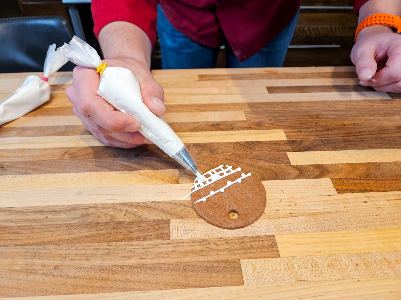 Demonstration of how to decorate gingerbread cookies as round ornaments.