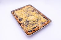 Sheet Kolach with Streusel Baked Sheet Kolach with Streusel showing golden crumb topping and dark berry filling peeking through, on a metal tray.