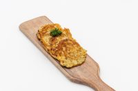 Side Potato Pancakes Bramboráčky Two golden Side Potato Pancakes Bramboráčky stacked on a wooden board with a herb garnish.